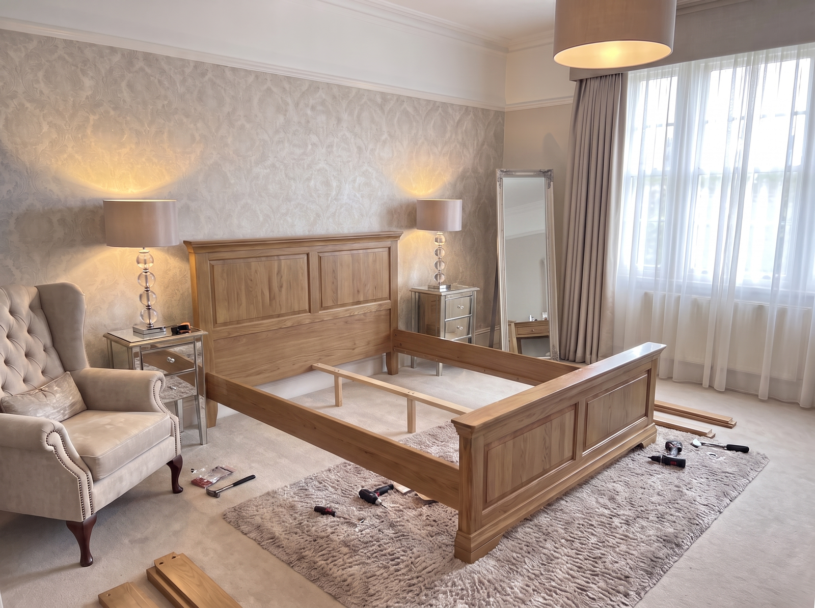 Solid oak bed frame being assembled in a customer's bedroom